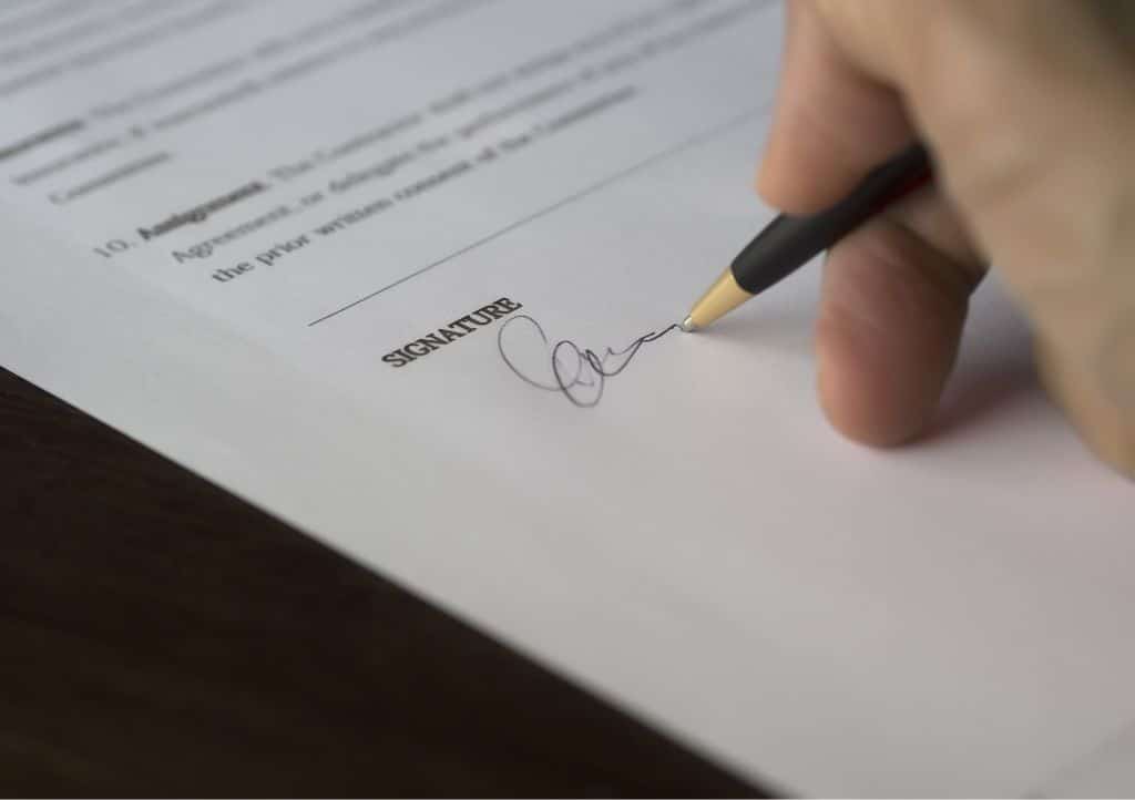 Hand signing an engagement letter to begin the veterinary practice sale process.